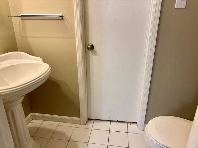 half bath featuring tile patterned floors and toilet