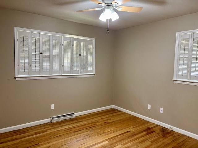 empty room featuring visible vents, ceiling fan, wood finished floors, and baseboards