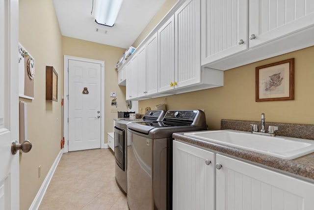 128A Montego Bay Rd, Milledgeville, GA 31061 - laundry area featuring independent washer and dryer, cabinet space, baseboards, and light tile patterned flooring