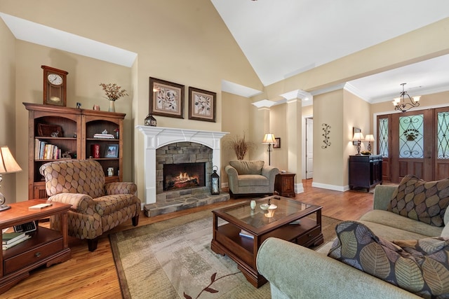 128A Montego Bay Rd, Milledgeville, GA 31061 - living area with a stone fireplace, wood finished floors, a chandelier, lofted ceiling, and baseboards