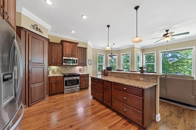 128A Montego Bay Rd, Milledgeville, GA 31061 - kitchen with stainless steel appliances, light wood-type flooring, backsplash, light stone counters, and ornamental molding