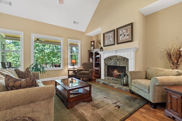 128A Montego Bay Rd, Milledgeville, GA 31061 - living area with a stone fireplace, plenty of natural light, wood finished floors, high vaulted ceiling, and a ceiling fan