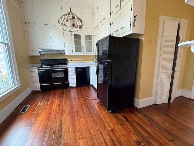 120 Franklin St, Milledgeville, GA 31061 - kitchen featuring black appliances, under cabinet range hood, dark wood-type flooring, baseboards, and light countertops