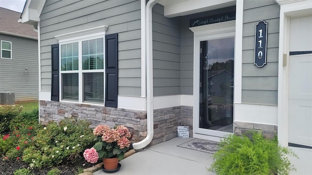 110 Colin Ln, Eatonton, GA 31024 - doorway to property featuring stone siding, central air condition unit, and a porch