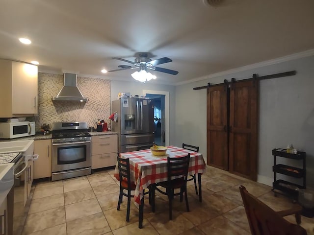 1745 Cedarwood Dr, Milledgeville, GA 31061 - kitchen featuring stainless steel appliances, wall chimney range hood, ornamental molding, a barn door, and a ceiling fan