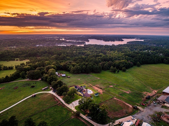 aerial view at dusk with a water view and a rural view