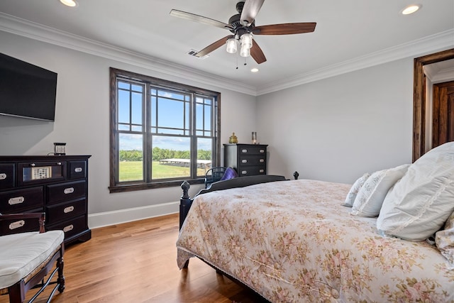 bedroom with ceiling fan, crown molding, and light hardwood / wood-style flooring