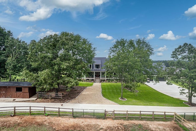 rear view of house featuring a yard, a rural view, and an outdoor structure