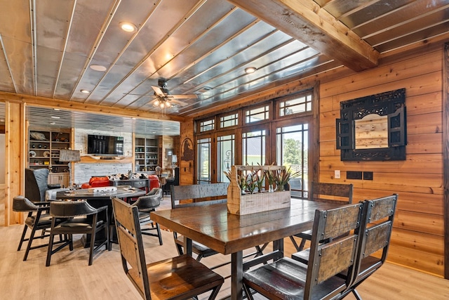 dining space featuring beam ceiling, ceiling fan, built in features, and light wood-type flooring