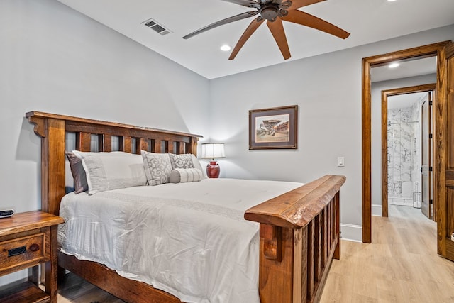 bedroom featuring ensuite bathroom, light hardwood / wood-style flooring, and ceiling fan