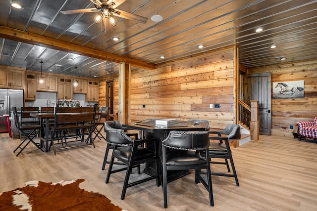 dining space featuring beam ceiling, light wood-type flooring, and ceiling fan