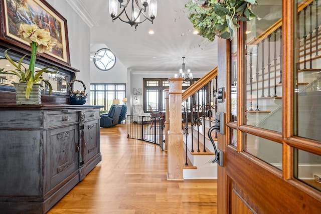 entryway featuring a notable chandelier, crown molding, and light hardwood / wood-style flooring