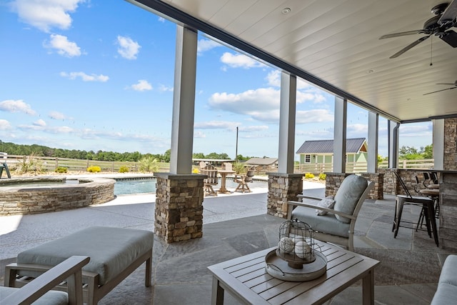 view of patio / terrace with ceiling fan and a swimming pool with hot tub