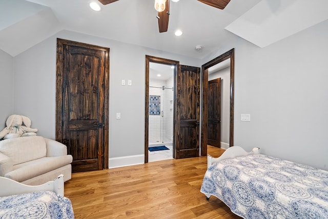 bedroom featuring connected bathroom, ceiling fan, light hardwood / wood-style floors, and vaulted ceiling