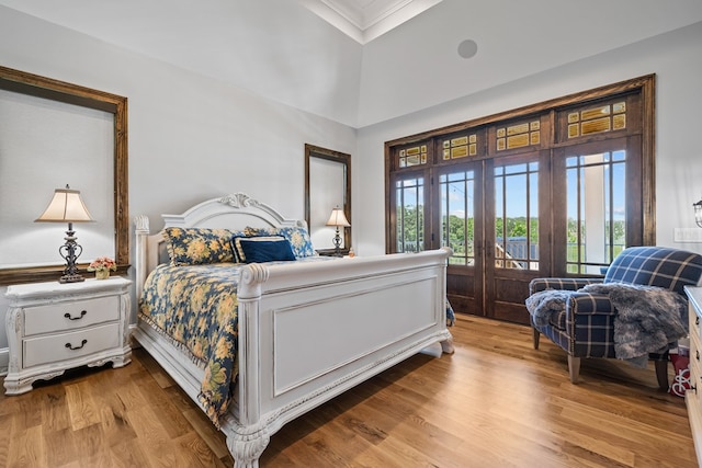 bedroom featuring access to exterior, light hardwood / wood-style flooring, and french doors