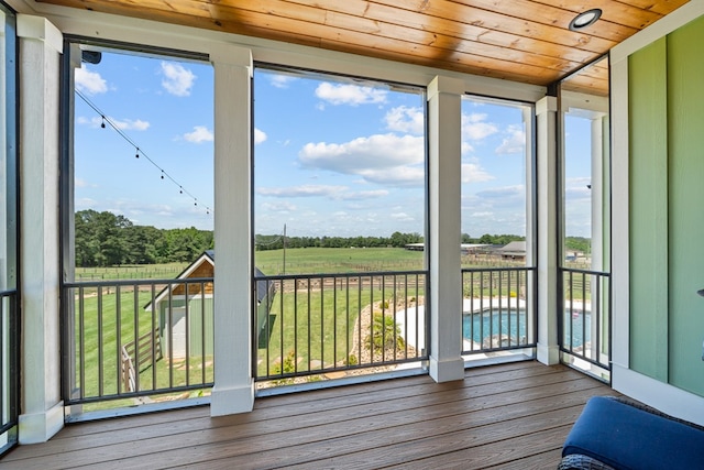 unfurnished sunroom with wooden ceiling and a rural view