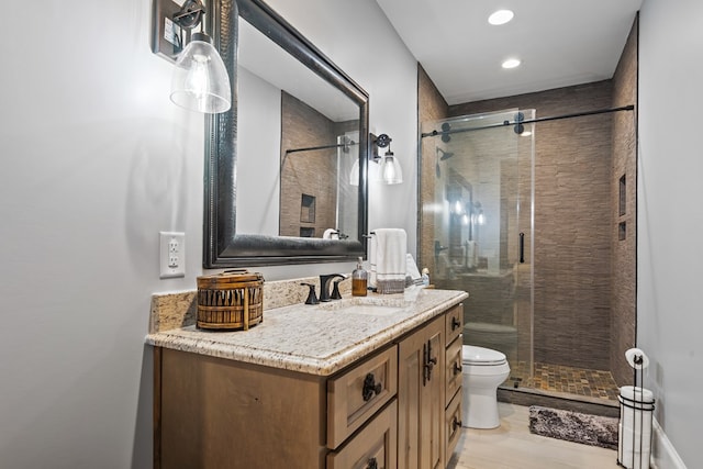 bathroom with hardwood / wood-style flooring, toilet, vanity, and walk in shower