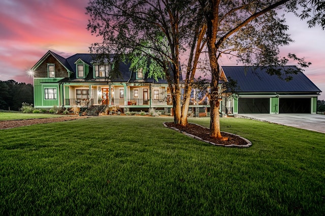 view of front of property with a porch, a yard, and a garage