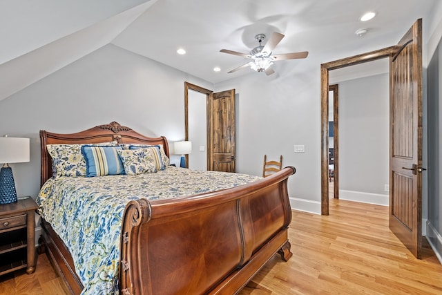 bedroom featuring ceiling fan, light hardwood / wood-style floors, and lofted ceiling