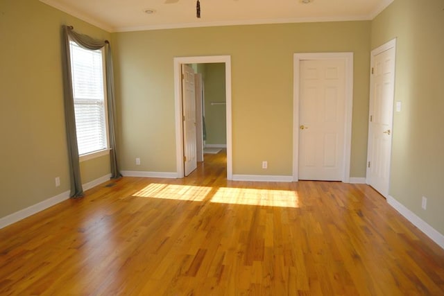 unfurnished bedroom featuring light wood-style flooring, ornamental molding, and baseboards