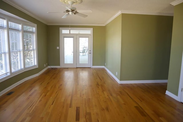 foyer entrance featuring ornamental molding, wood finished floors, and baseboards