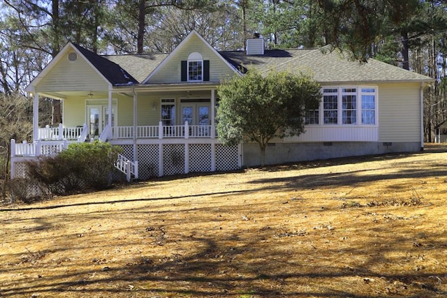 view of front facade with a porch, french doors, and a front lawn