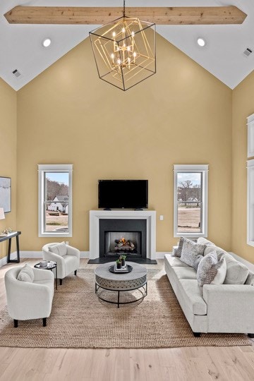 living room featuring wood-type flooring, beam ceiling, and high vaulted ceiling