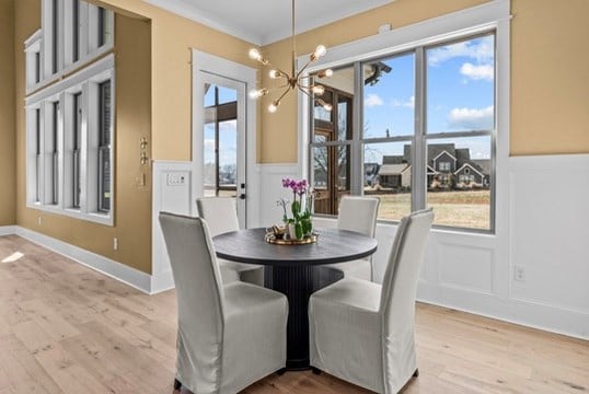 dining space featuring an inviting chandelier, crown molding, and light wood-type flooring