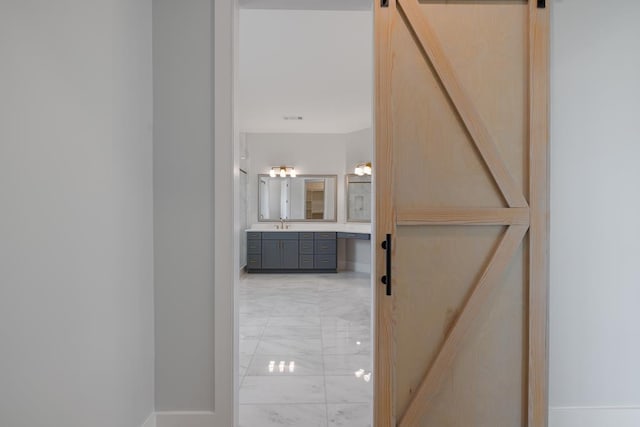 corridor featuring a barn door and sink