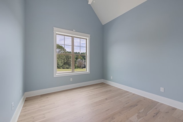 unfurnished room with light wood-type flooring and high vaulted ceiling