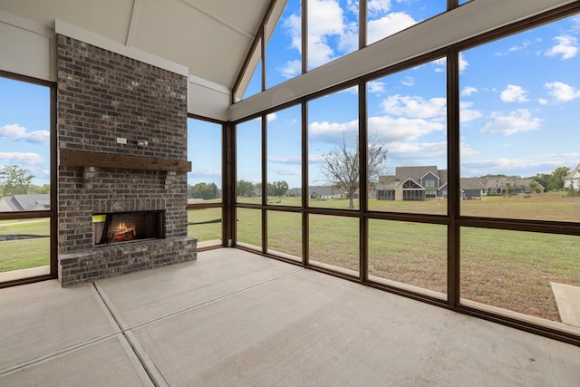 unfurnished sunroom featuring a brick fireplace and a wealth of natural light