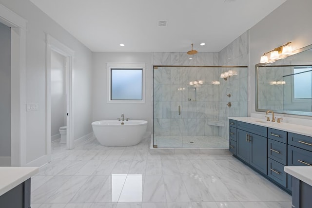 bathroom featuring vanity, plus walk in shower, and a wealth of natural light