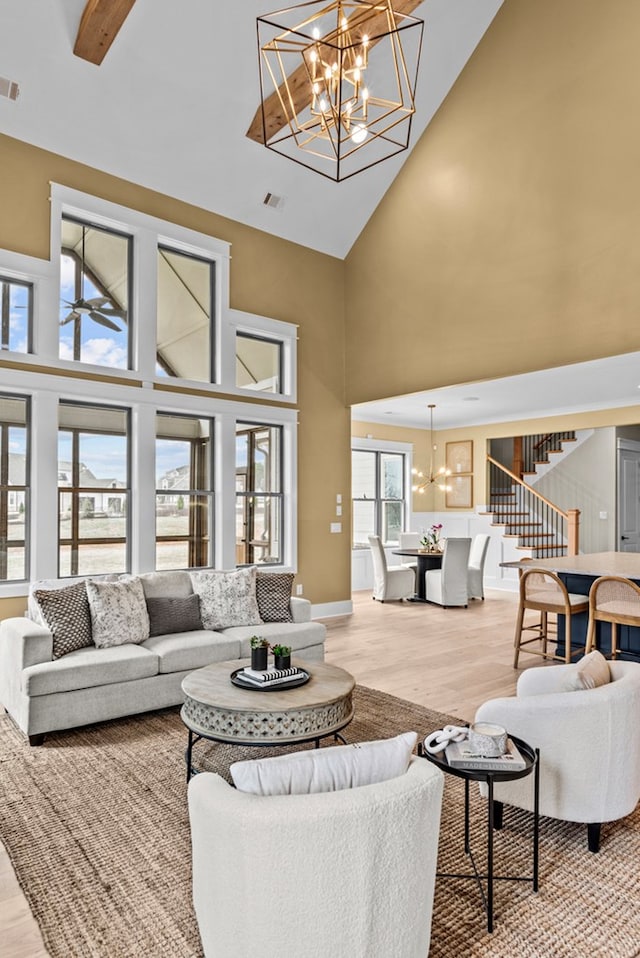 living room with a notable chandelier, hardwood / wood-style flooring, and high vaulted ceiling