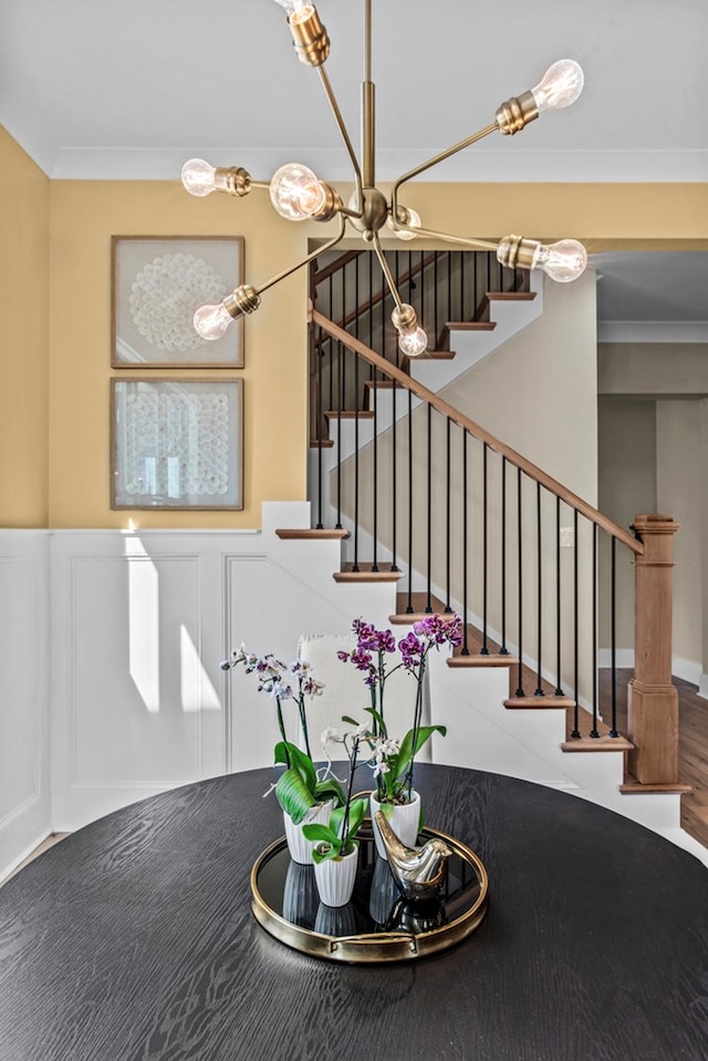 stairs featuring ornamental molding and a chandelier