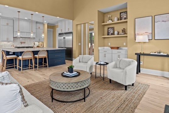 living room with built in shelves and light wood-type flooring