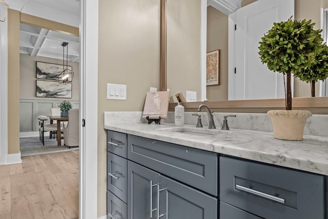 bathroom featuring beamed ceiling, wood-type flooring, coffered ceiling, and vanity