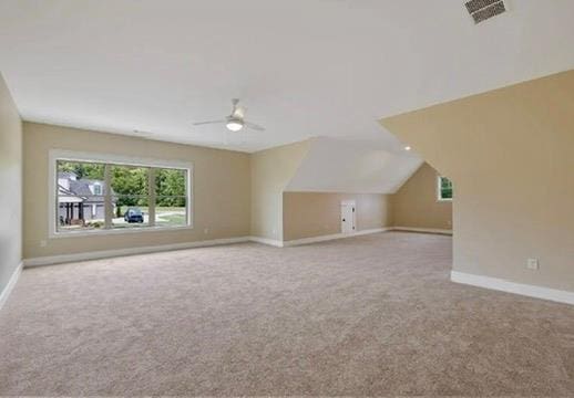 additional living space with lofted ceiling, light colored carpet, and ceiling fan