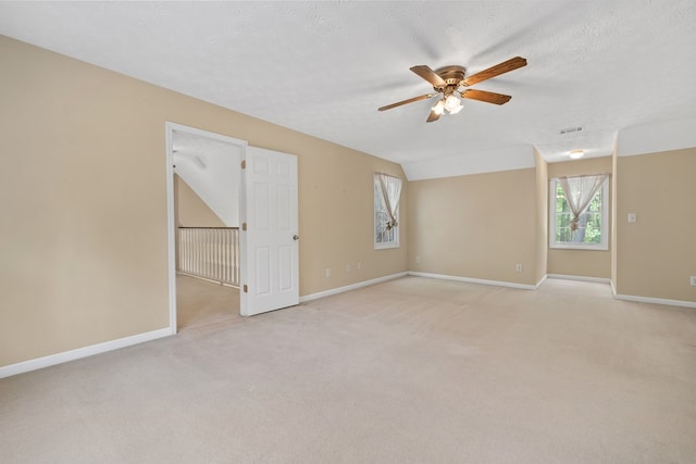 unfurnished room with a ceiling fan, baseboards, light colored carpet, and visible vents