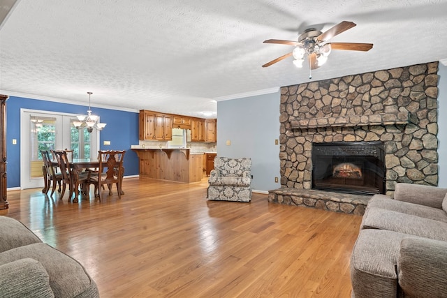 living room featuring crown molding, a textured ceiling, light wood finished floors, and ceiling fan with notable chandelier