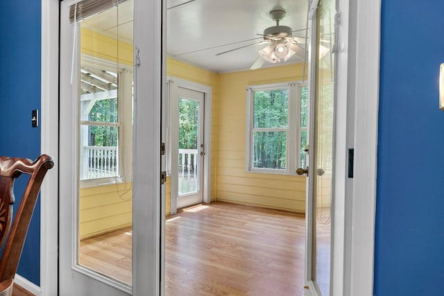 doorway featuring a ceiling fan and light wood finished floors