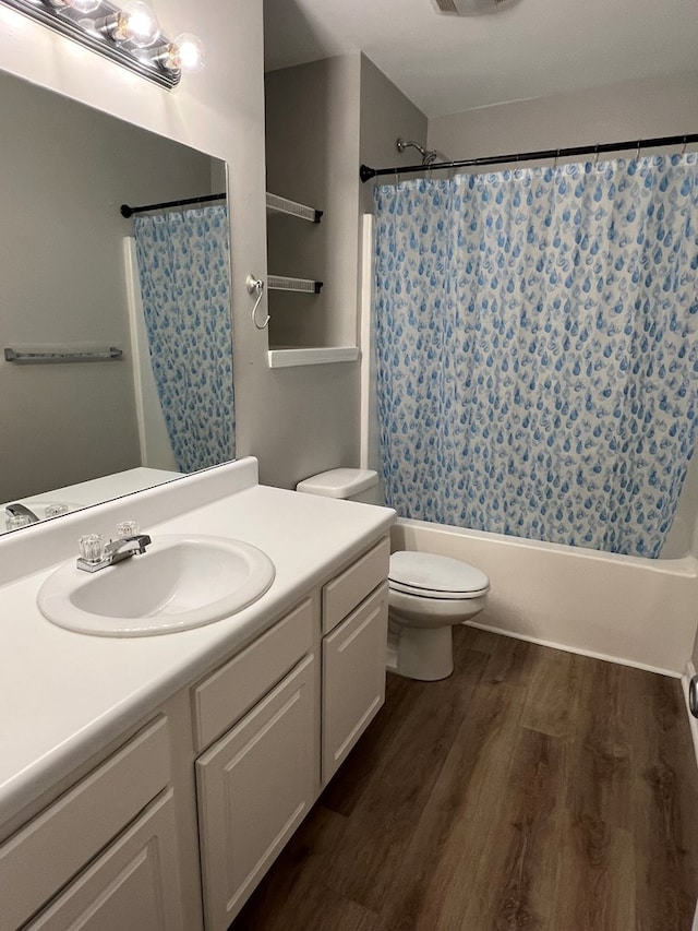 full bathroom with shower / bath combo, hardwood / wood-style floors, vanity, and toilet