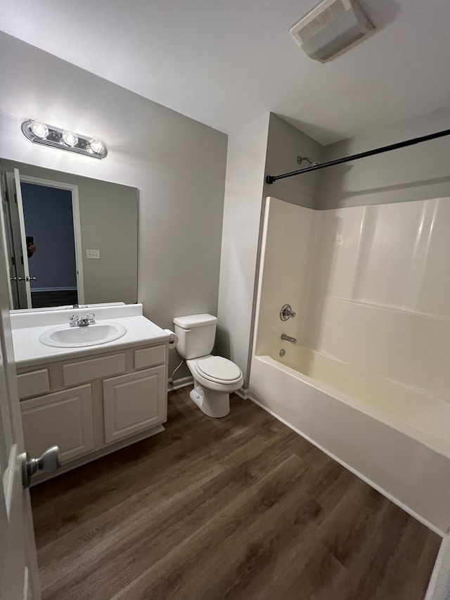 full bathroom with toilet, shower / bath combination, wood-type flooring, and vanity