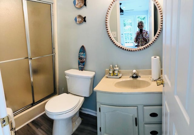 bathroom featuring toilet, vanity, wood-type flooring, and walk in shower