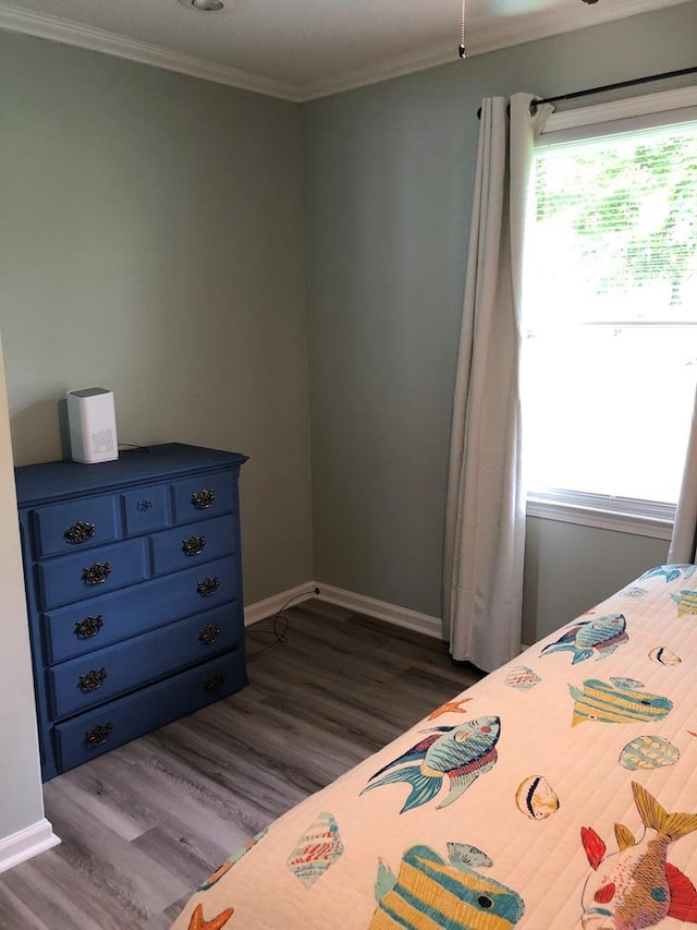 bedroom with dark hardwood / wood-style floors, crown molding, and multiple windows