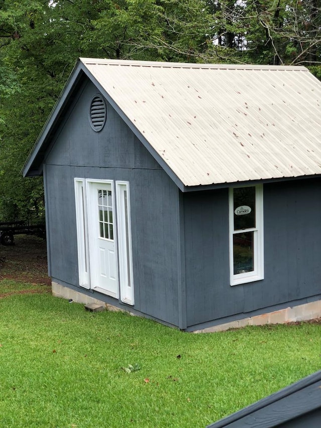 view of outbuilding featuring a lawn