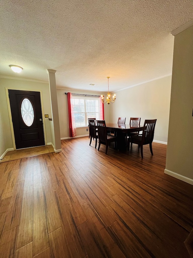 dining area with a notable chandelier, crown molding, a textured ceiling, and wood-type flooring