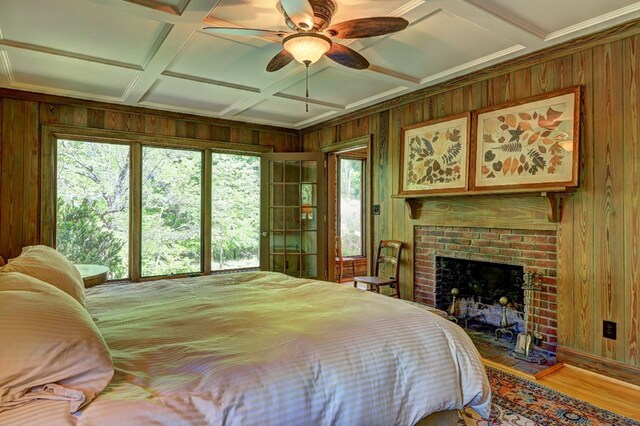 136 Kings Rd, Milledgeville, GA 31061 - bedroom featuring wooden walls, coffered ceiling, wood finished floors, multiple windows, and a brick fireplace
