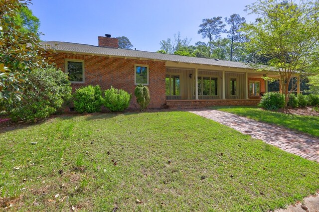 136 Kings Rd, Milledgeville, GA 31061 - rear view of property with a chimney, a lawn, brick siding, and board and batten siding