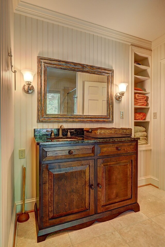 136 Kings Rd, Milledgeville, GA 31061 - bathroom featuring built in features, vanity, ornamental molding, tile patterned floors, and wooden walls