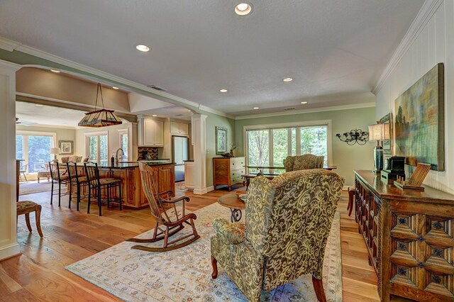 136 Kings Rd, Milledgeville, GA 31061 - living area with healthy amount of natural light, crown molding, ornate columns, light wood finished floors, and recessed lighting
